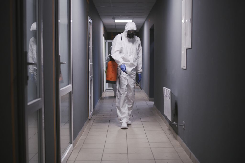 Man in a hazmat suit disinfecting a building in Orlando, FL