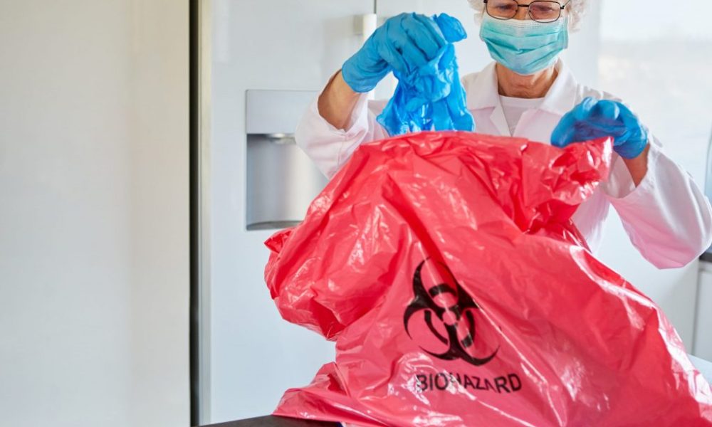 Biohazard Cleanup crew member putting trash in red bag in Sanford, FL